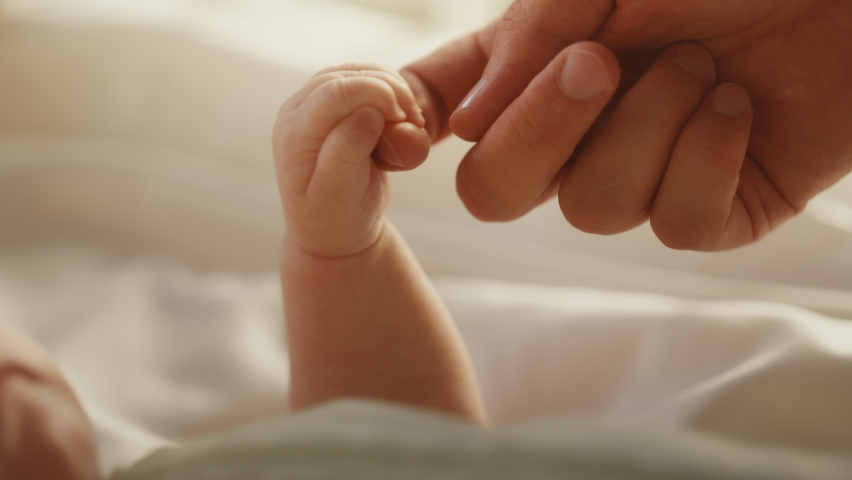 Close Up Footage of Newborn Baby Playing With Mother's Hand and Finger while Lying on the Back in Child Crib. Caucasian Neonate Toddler Bodning with Mom. Concept of Childhood, New Llife and Parenthood | Shutterstock HD Video #1063762990