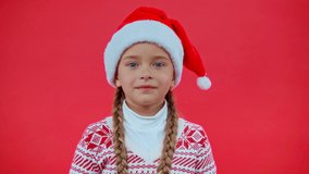 shocked girl in santa hat isolated on red