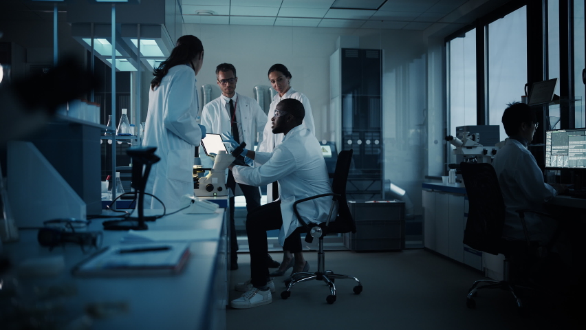 Medical Science Laboratory with Diverse Multi-Ethnic Team of Microbiology Scientists Have Meeting on Developing Drugs, Medicine, Doing Biotechnology Research. Working on Computers, Analyzing Samples | Shutterstock HD Video #1063773154