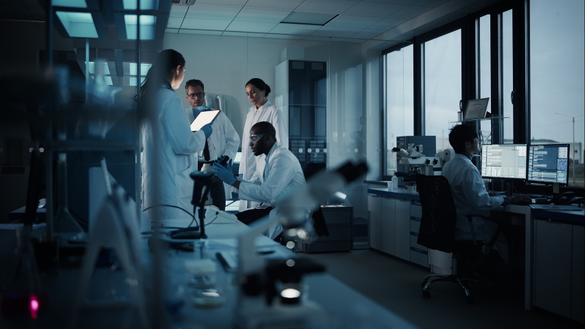 Medical Science Laboratory with Diverse Multi-Ethnic Team of Microbiology Scientists Have Meeting on Developing Drugs, Medicine, Doing Biotechnology Research. Working on Computers, Analyzing Samples Royalty-Free Stock Footage #1063773157