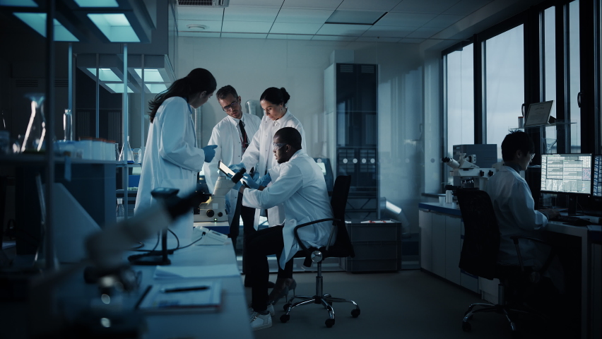 Medical Science Laboratory with Diverse Multi-Ethnic Team of Microbiology Scientists Have Meeting on Developing Drugs, Medicine, Doing Biotechnology Research. Working on Computers, Analyzing Samples | Shutterstock HD Video #1063773157