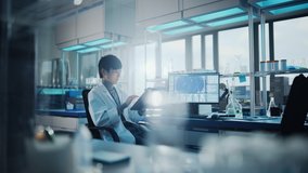 Medical Development Laboratory: Portrait of Asian Male Scientist Using Touch Screen Digital Tablet Computer, Doing Data Analysis Research. Biotechnology Specialists in Advanced Scientific Lab. - Powered by Shutterstock - Get 15% off with code: PIKWIZARD15
