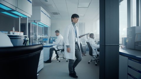 Medical Science Laboratory with Diverse Multi-Ethnic Team of Scientists Developing Drugs, Medicine, Doing Biotechnology Research. Working on Computer, Using Microscope, Analysing Samples. Slow Motion