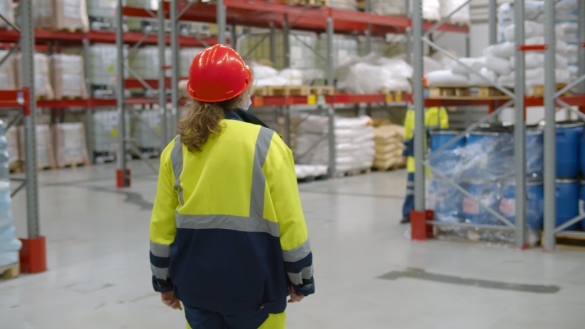 Diverse warehouse workers in face mask do elbow bump greeting. Industrial engineers wearing protective mask meeting in factory warehouse and bumping elbows Royalty-Free Stock Footage #1063776388