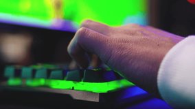 Close-up of hands of gamer guy playing video game with mouse and keyboard