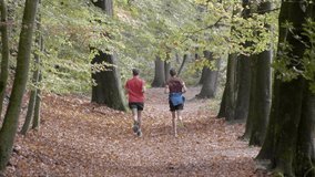 Two Guys jogging at the park in autumn, Slow motion 4K