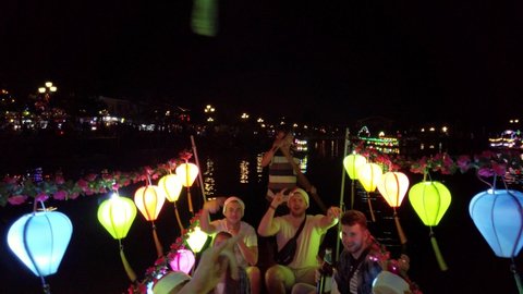 Hoi An , Vietnam - 12 24 2019: Caucasian male and female tourists having fun on a lantern party boat on the Thu Bon River at night