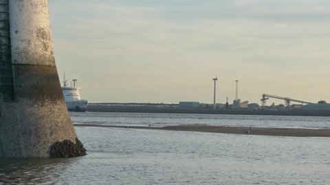 Wirral , Liverpool , United Kingdom (UK) - 06 05 2020: Stena Line passenger ferry emerging from behind coastal lighthouse route passing harbour port seascape