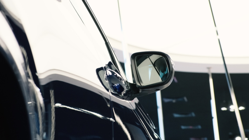 Side door windows and rearview mirror of a new SUV from a premium car brand. Sale of new cars in the dealer showroom.