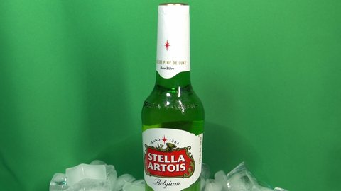 Edmonton , AB , Canada - 12 03 2020: Sealed rotating 360 degrees green bottled Stella Artois plsner beer placed ontop of a stack of ice in a beverage bucket. This Belgian carbonated drink has kept its