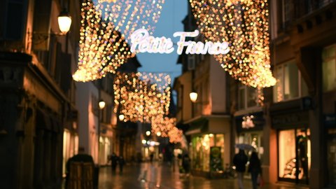 Defocused view of pedestrian street with Petite France inscription and Christmas Decorations in central Strasbourg on a Black Friday - partial lockdown therfore fewer customers