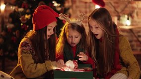 Three exited, Extremely Happy Sisters, Friends opening, unpacking their Christmas Gifts in the Cozy Evening. Big Family celebrating Winter Fests, opening Christmas Santas Presents. Festive Mood. - Powered by Shutterstock - Get 15% off with code: PIKWIZARD15