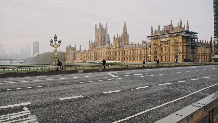 London in Coronavirus Covid-19 lockdown with empty quiet deserted roads and streets with no cars or traffic at Westminster Bridge with Houses of Parliament in England, UK at rush hour | Shutterstock HD Video #1063805497