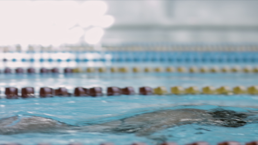 Young female swimmer performing front crawl technique. Sport and endurance theme. Camera moving with woman swimmer. | Shutterstock HD Video #1063818469