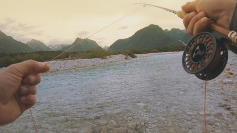 Fisherman's POV of catching fish using the flyfishing technique with a reel