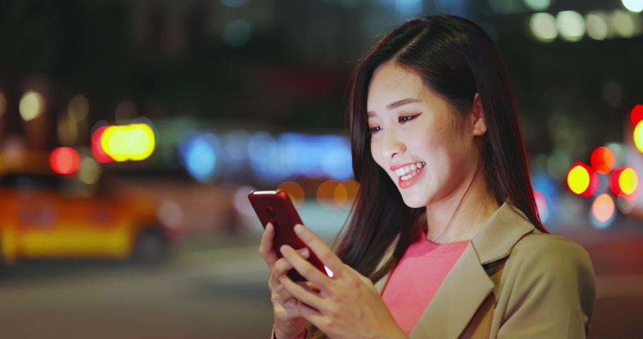 asian woman use smart phone and hail a taxi on road to commute in the city at night Royalty-Free Stock Footage #1063820395