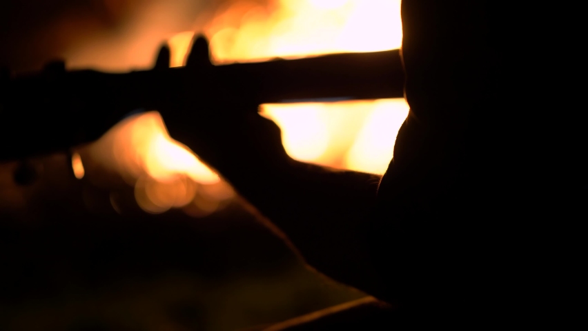Cinematic Silhouette Of Man Playing Acoustic Guitar By Bonfire | Shutterstock HD Video #1063828966
