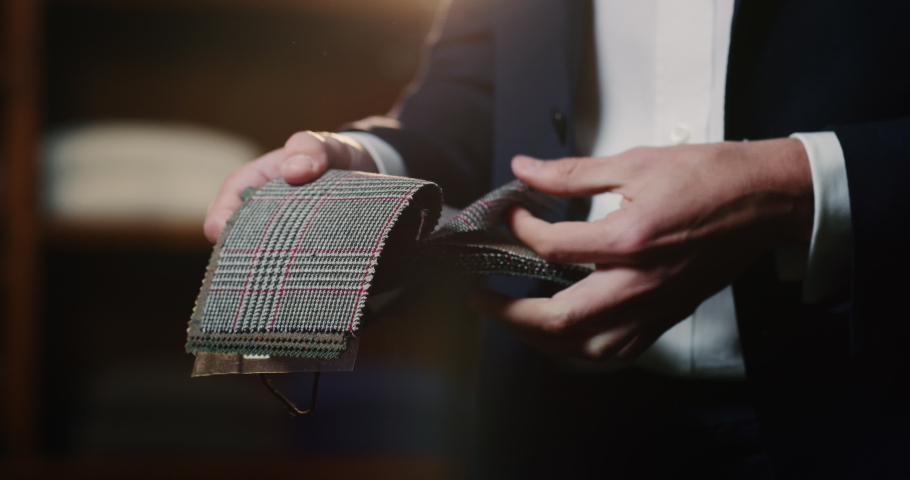 Cinematic shot of young businessman is choosing fabrics for his new custom tailored suit by designer in a luxury tailoring atelier. Concept of fashion, handmade, hand craft, couturier and business. Royalty-Free Stock Footage #1063832404
