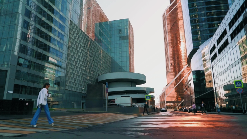 Girl with coffee in her hands rushing to work in the business center, early morning in Moscow city.