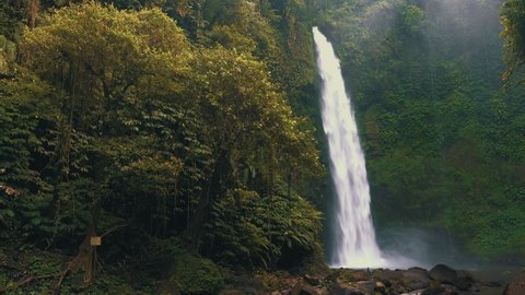 Amazing Nungnung waterfall hidden in tropical rainforest island Bali, Indonesia. 4K