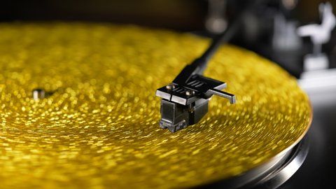 Fortuna gold, movie of retro-styled record player spinning vinyl golden record. Cinemagraph. Side view. Analog audio equipment, sound concept.