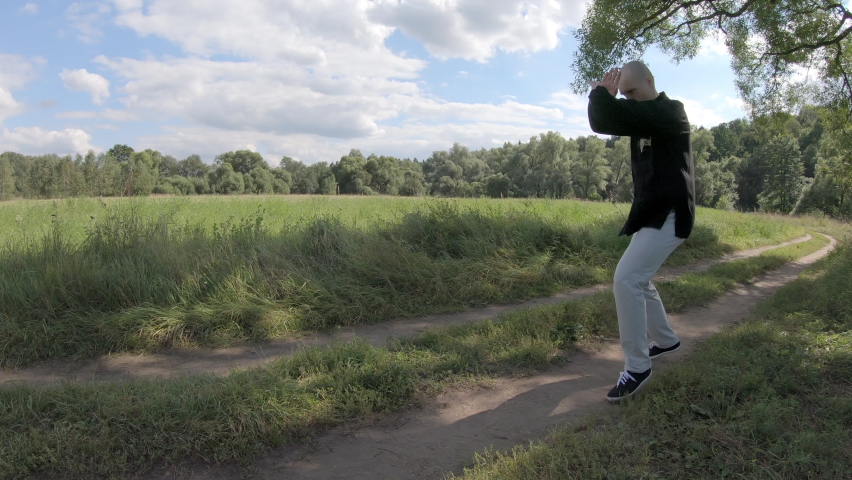 Man in Chinese clothing moves in the style of Bruce Lee, then punches and kicks