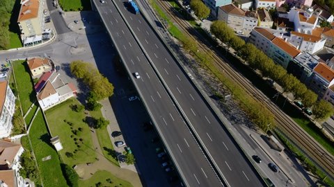 Aerial view following cars and trucks on road in Alhandra, sunny day,in Lisbon, Portugal - tilt up, drone shot