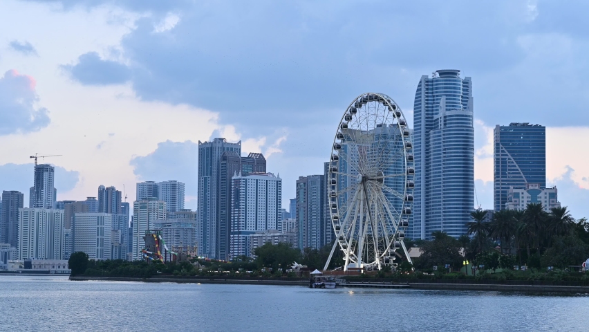 Dec 2020: The iconic Eye of the Emirates wheel of Sharjah, Sharjah Skyline in the background on a cloudy evening, United Arab Emirates, 4K video