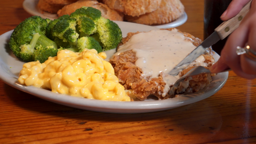 Steak knife cuts forkful of chicken fried steak, a comforting bite of southern food, slider 4K