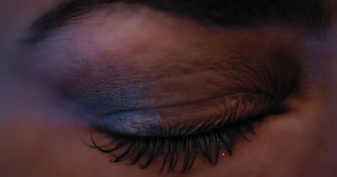 Close up of a woman's eye with beautiful makeup, opening in a studio lighting. Slow motion. BMPCC 4K.