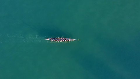 Dragon Boat team rowing to the pace of an onboard Drummer, Aerial view.