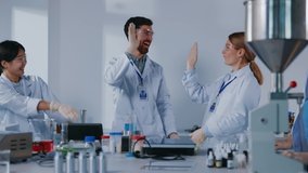 Happy cooperative science team of medical workers successfully developing vaccination or medicine giving high-five applauding celebrating victory in laboratory. - Powered by Shutterstock - Get 15% off with code: PIKWIZARD15