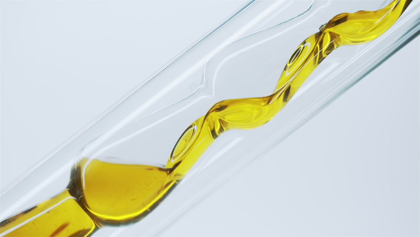 Yellow natural oil flows through a laboratory glass tube. Obtaining essential oils by filtration. Production of natural cosmetics. Royalty-Free Stock Footage #1063883932