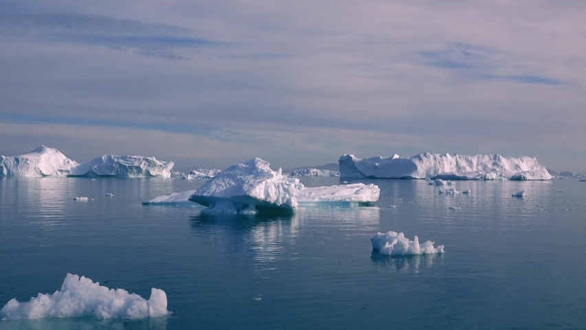 Cruising in Antarctica. Giant floating Iceberg from melting glacier in Antarctica. Global Warming and Climate Change. Landscape of snowy mountains and icy shores in Antarctica. Royalty-Free Stock Footage #1063884967