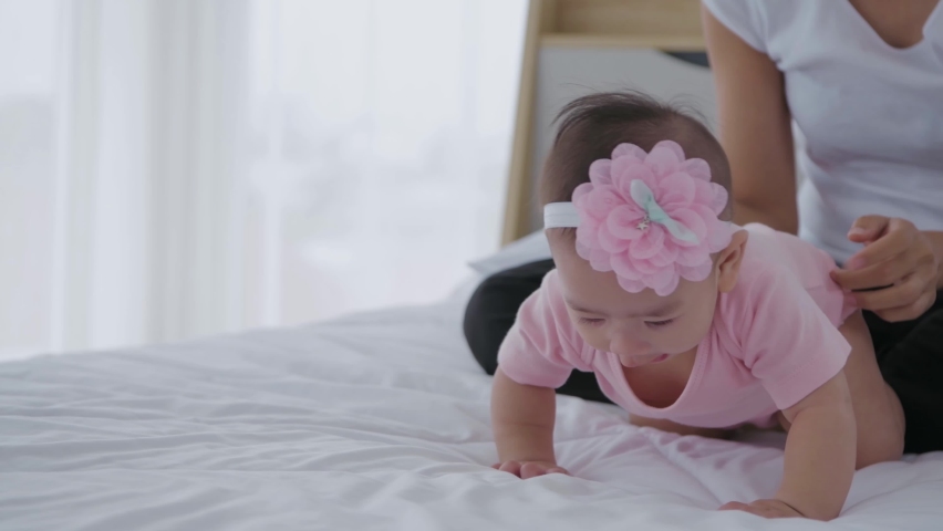 Family concept of 4k Resolution. Mother playing with baby in the bedroom.