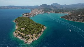 Aerial drone video of picturesque city of Ermioni built in peninsula with forest of Bistis at the end, Argolida, Peloponnese, Greece