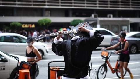 Sao Paulo, State of Sao Paulo, Brazil. November 2020. Street musician playing electric guitar to the crowd at the avenue.