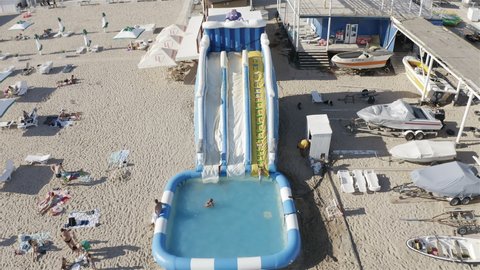 Russia, Crimea, Evpatoria, August 3, 2020 a girl climbs the stairs to an inflatable water slide.