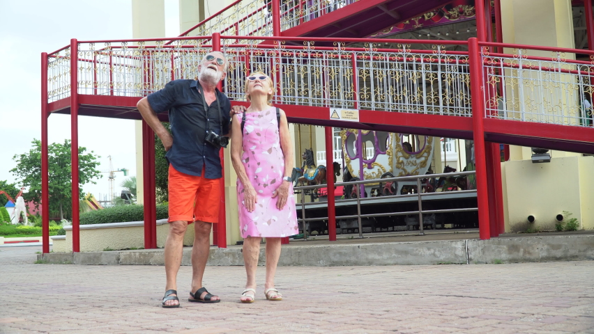 Happy senior couple at the amusement park outdoors in summer.  crazy old man and funny mature woman  having fun in vacation