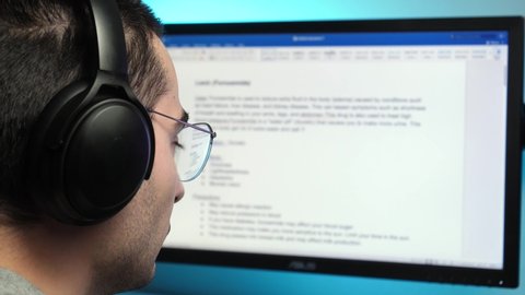 Writing a text in a text editor on a computer monitor wearing headphones at home. freelancer, student concept shot.