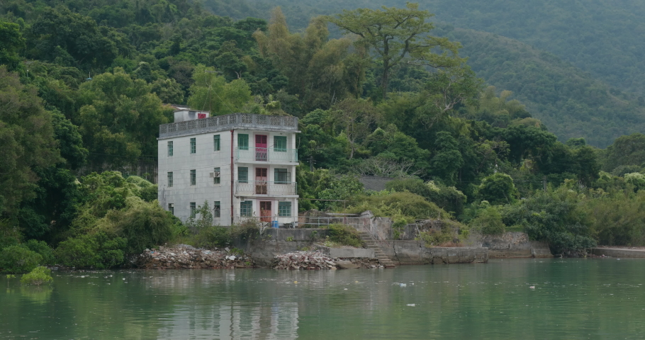 Old house on island beside the sea with boat