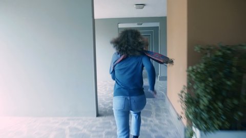 young curly haired woman running from a rapist in the lobby of building