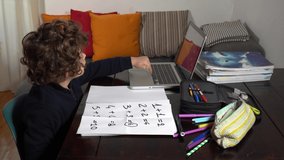 6 year old boy takes lessons with his father, school closure due to Covid-19 Coronavirus lockdown quarantine home - lifestyle in family . Lesson with lap top computer 
