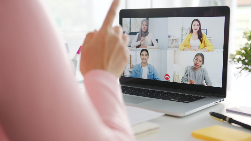 Young Asia businesswoman using laptop talk to colleague about plan in video call meeting while work from home at living room. Self-isolation, social distancing, quarantine for corona virus prevention. | Shutterstock HD Video #1063943608