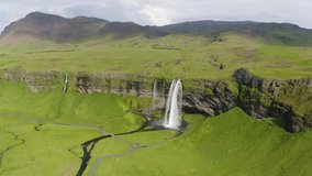Flying around the Seljalandsfoss Waterfall on the Seljalands River in Iceland. 4K UHD video.