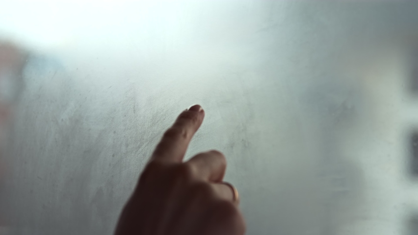 A hand draws a heart shape on the window with her finger. Fell in love. Shares love with the whole world and charity concept. Selective focus. | Shutterstock HD Video #1063950472