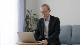 asian senior man talking video chat on a computer
