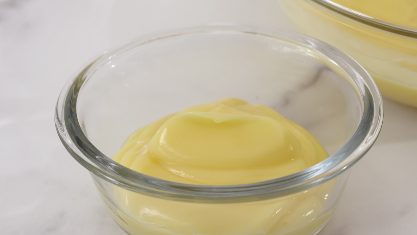 Lemon pudding or lemon curd served with mint leaves and sliced lemon recipe. Serving pudding in a glass bowls Royalty-Free Stock Footage #1063957366