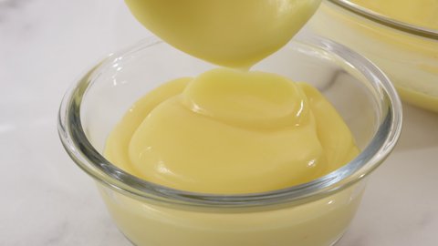 Lemon pudding or lemon curd served with mint leaves and sliced lemon recipe. Serving pudding in a glass bowls