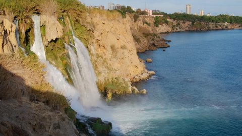 Lower Duden waterfalls on Mediterranean sea coast in Antalya, Turkey. Slow panning of the famous Duden falls in Antalya city at sunset
